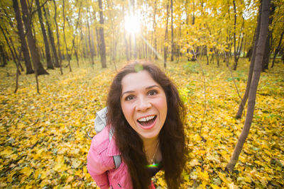 Portrait of smiling young woman against plants