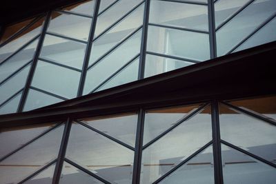 Low angle view of glass building against sky