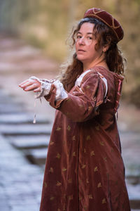 Woman looking away while standing outdoors