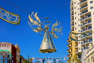 Low angle view of decorations on building against clear blue sky
