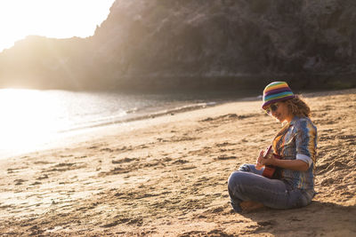 Man sitting on sand at beach