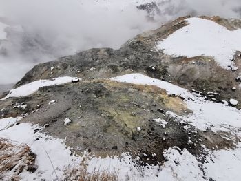 Snow covered rocks against mountain