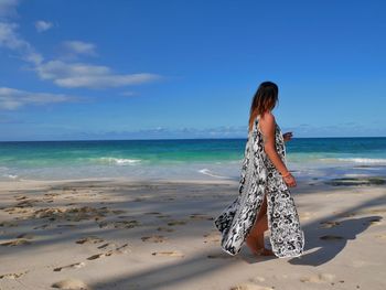 Woman at beach against sky