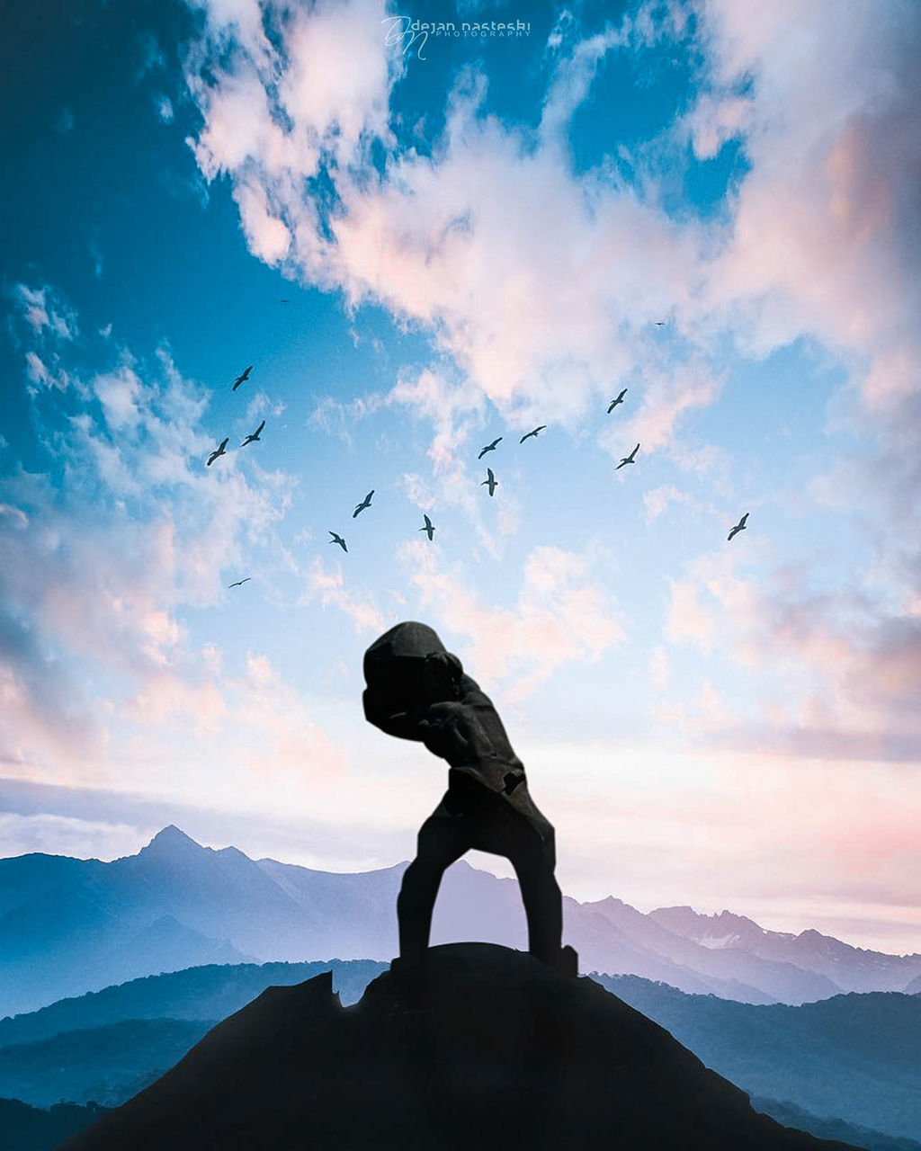 SILHOUETTE PERSON FLYING AGAINST MOUNTAINS