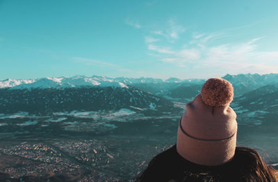 Rear view of woman looking at snowcapped mountain against sky