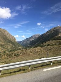 Road by mountains against sky