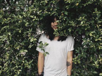 Midsection of woman standing against plants