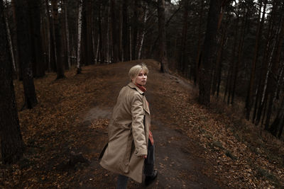 Rear view of portrait woman walking in forest