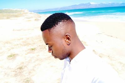 Close-up of man at beach against sky