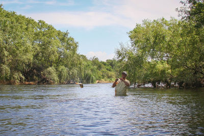 Rear view of woman standing in lake