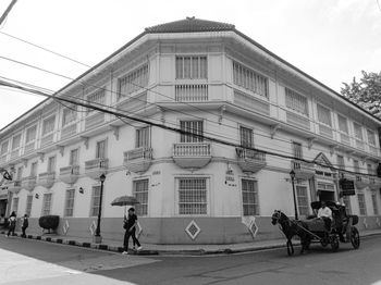 People riding bicycle on street against buildings in city