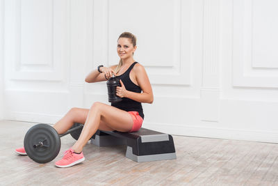 Young woman smiling while sitting on floor