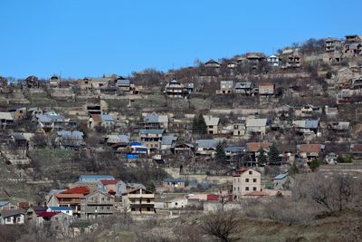 Houses in town against clear blue sky