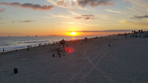 People at beach during sunset