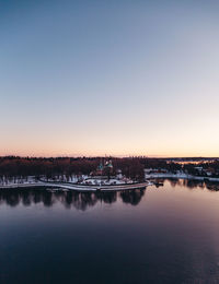 Scenic view of lake against clear sky at sunset