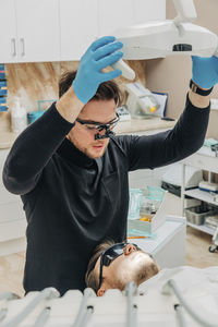 Dentist examining patient with medical equipment in clinic