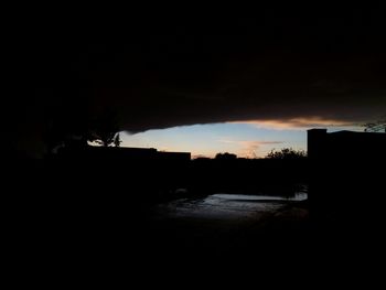 Silhouette buildings against sky at sunset