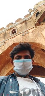 Portrait of young man against built structure