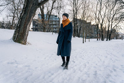 A woman walks on the snow-covered ground and smiles