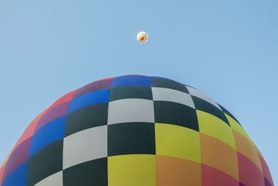 Low angle view of hot air balloon against clear blue sky