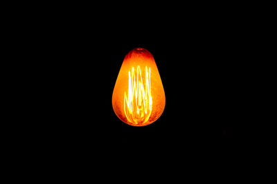 Close-up of illuminated lighting equipment against black background