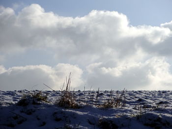 Snow covered landscape against sky