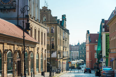 City street by buildings against sky