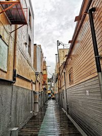 Alley amidst buildings in city against sky