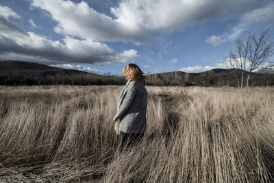 Woman standing on field against sky