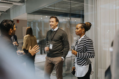 Delegates looking at businessman discussing strategy during networking conference