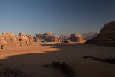 Panoramic view on the desert of wadi rum and its huge ochre rocks at sunrise.