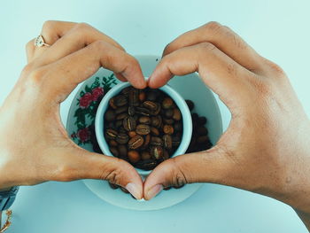 Close-up of hand holding coffee beans