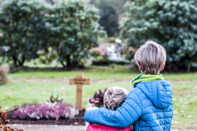 Siblings standing in graveyard