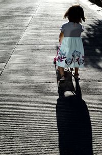 Rear view of woman walking on footpath