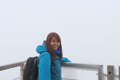 Portrait of smiling young woman standing in winter