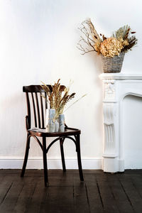 Empty chairs and table against wall