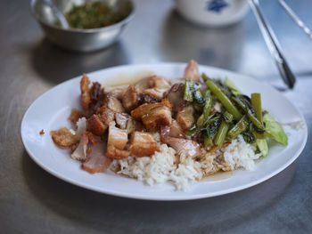 Barbecued red pork and crispy pork in sauce with rice .