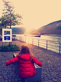 Rear view of woman sitting on bench