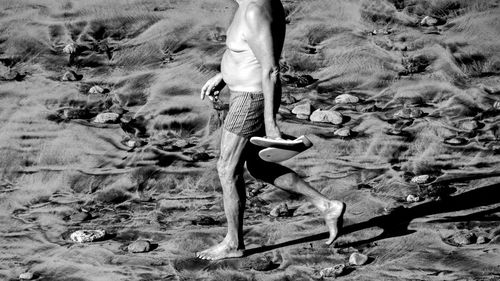 Low section of man standing on beach