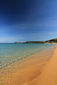 Scenic view of beach against clear blue sky