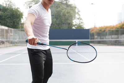 Midsection of man playing badminton