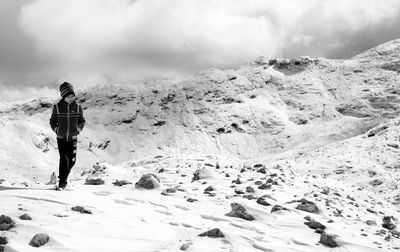 Rear view of woman walking on snow covered mountain