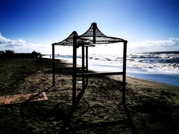 Lifeguard hut on beach against sky