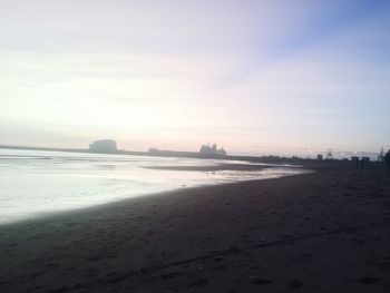 Scenic view of beach against sky during sunset