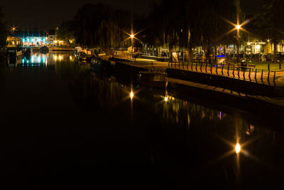 Boats moored in river at night