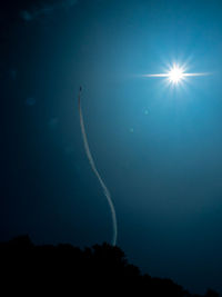 Low angle view of vapor trails in sky at night