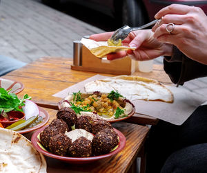 Cropped hand of person preparing food on table