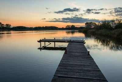 A pier on a calm lake and the sky after sunset