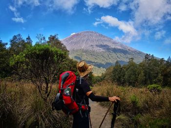 Rear view of woman on mountain against sky