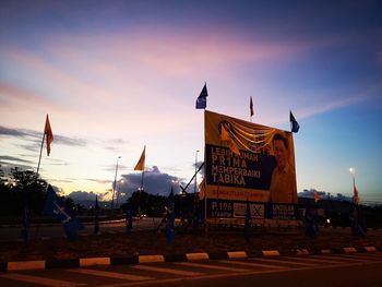 People on street amidst buildings against sky at dusk